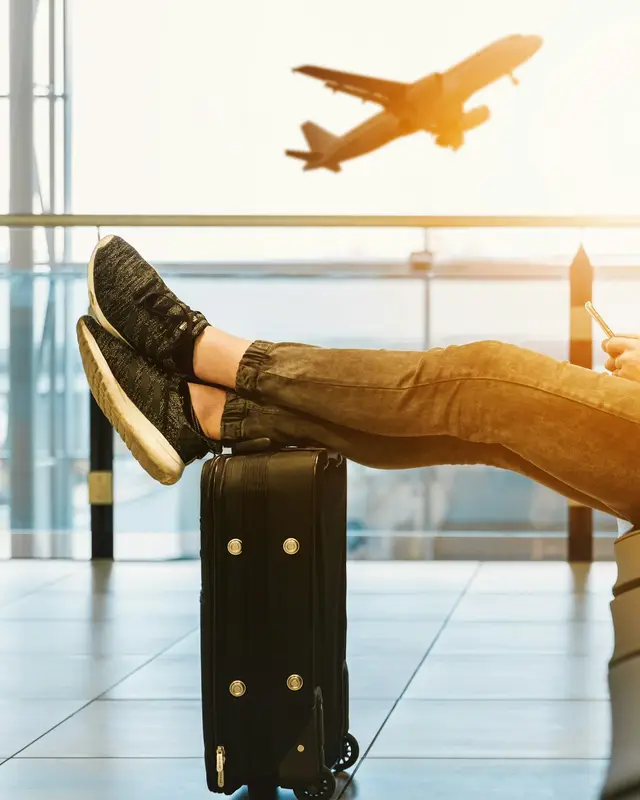 Traveller relaxing at an airport gate as a plane takes off