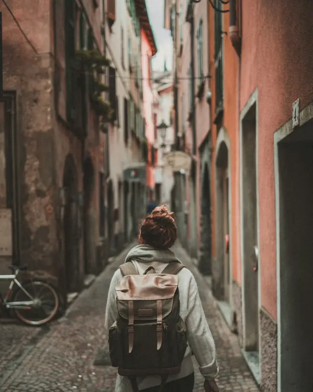 Traveller with a backpack walking through an old European street